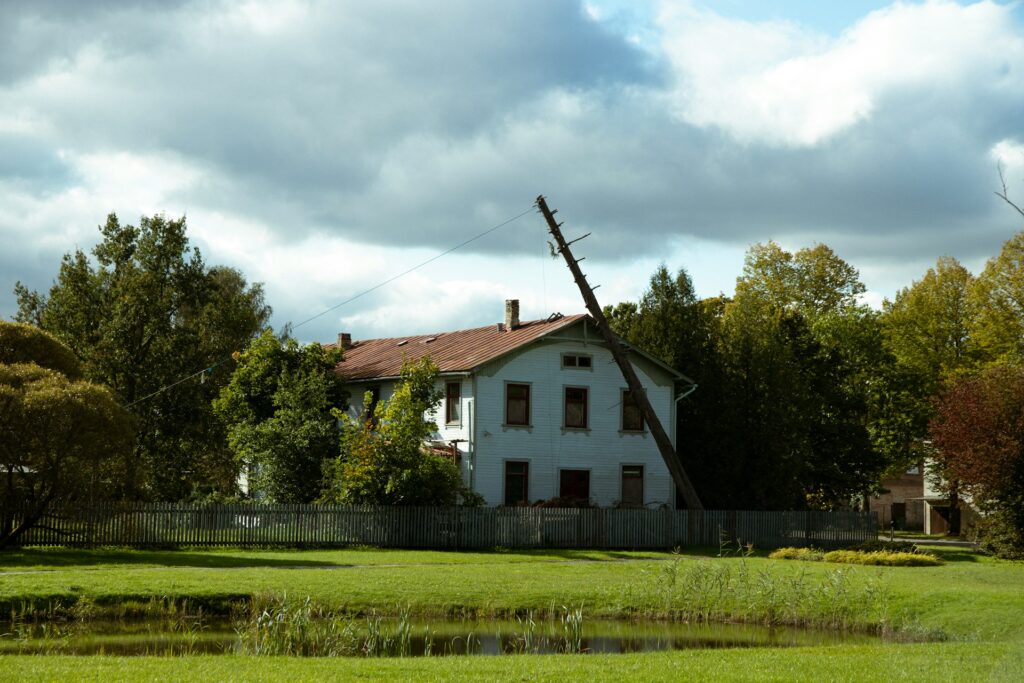 Medford homeowner inspecting roof from ground level after Rogue Valley wind storm checking for shingle damage