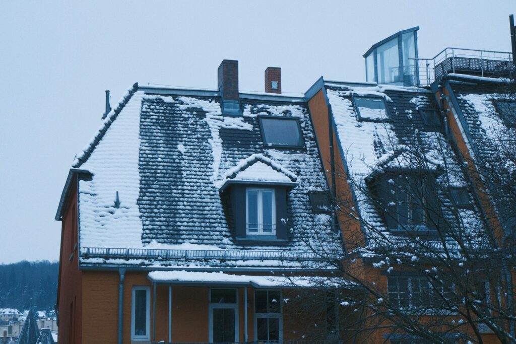 Bend Oregon roof showing freeze-thaw damage with ice and snow patterns on shingles against High Desert winter landscape