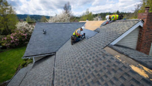 Roofing crew installing new architectural shingles on a Eugene Oregon home in spring