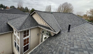 Roofing contractor inspecting moss-covered roof and gutters on a Vancouver Washington home in spring