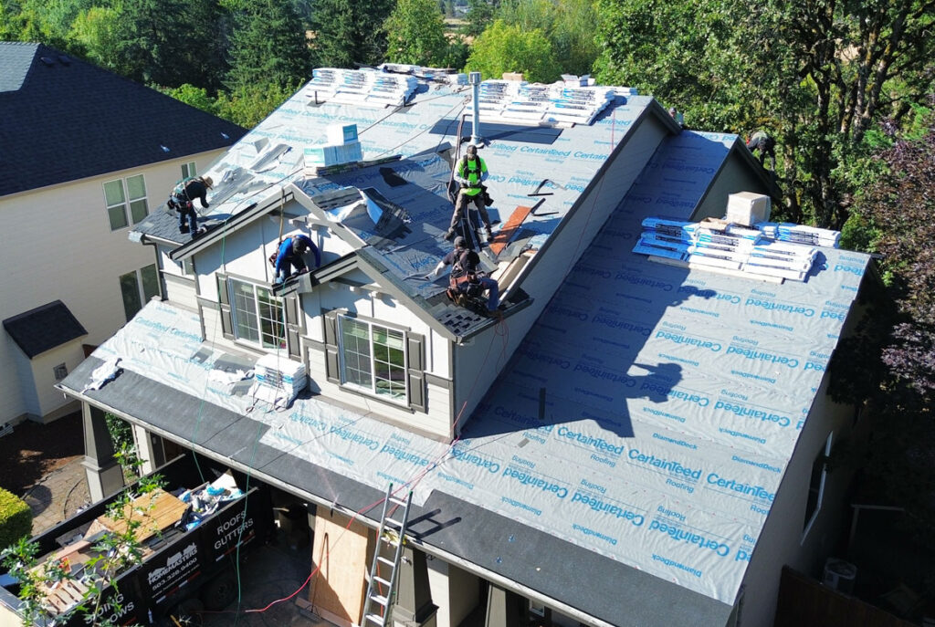HOMEMASTERS roofing crew repairing asphalt shingles on a Portland East Oregon home in summer