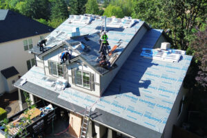 HOMEMASTERS roofing crew repairing asphalt shingles on a Portland East Oregon home in summer