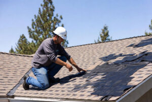 HOMEMASTERS roofing inspector examining hail damage on shingles of a Bend Oregon home in summer
