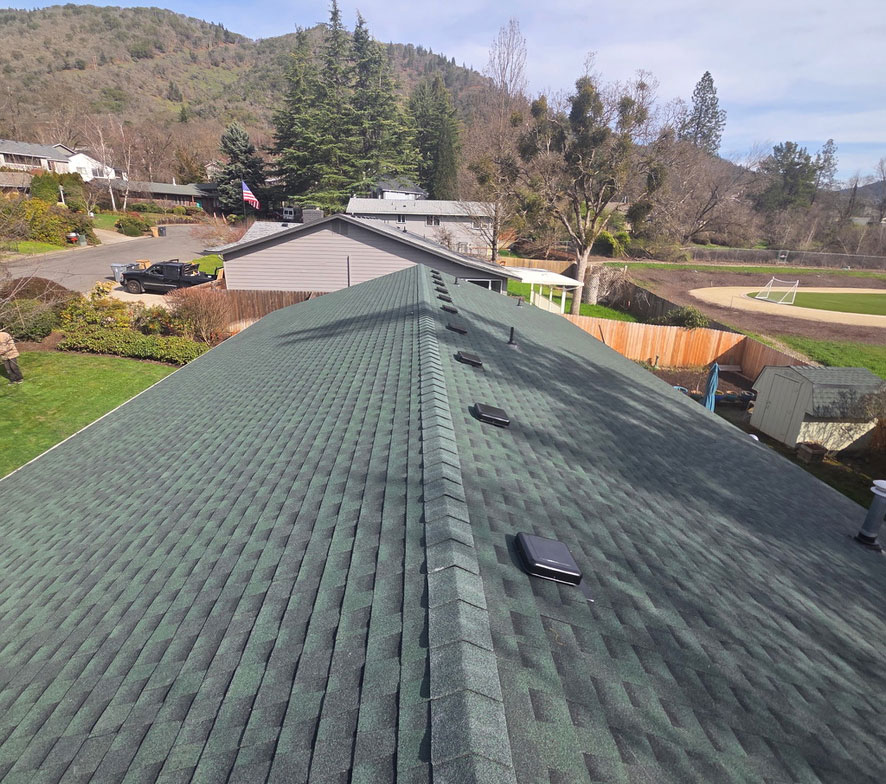 HOMEMASTERS Southern Oregon roofing inspector evaluating ridge and soffit ventilation on a Medford Oregon home