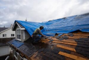 HOMEMASTERS Eugene crew installing an emergency roof tarp on a storm damaged Lane County home