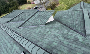 Roofing inspector examining asphalt shingles on a home in Orchards, WA to decide between repair and replacement