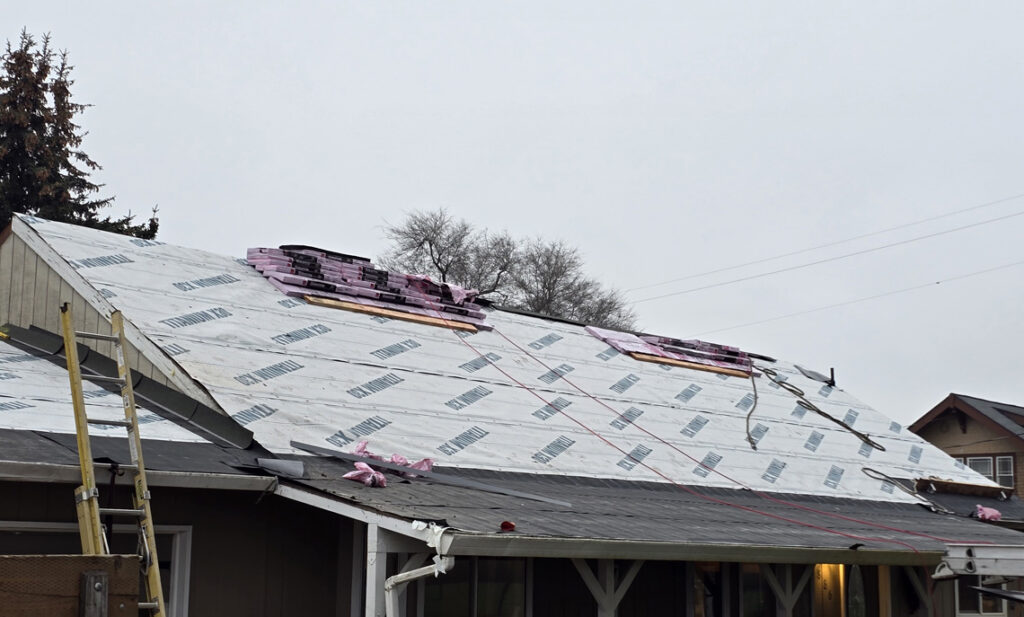 Homeowner reviewing a written roof replacement estimate at a kitchen table in Springfield, Oregon
