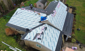 Roofing crew working on one building of a multi-building residential complex in Albany, Oregon