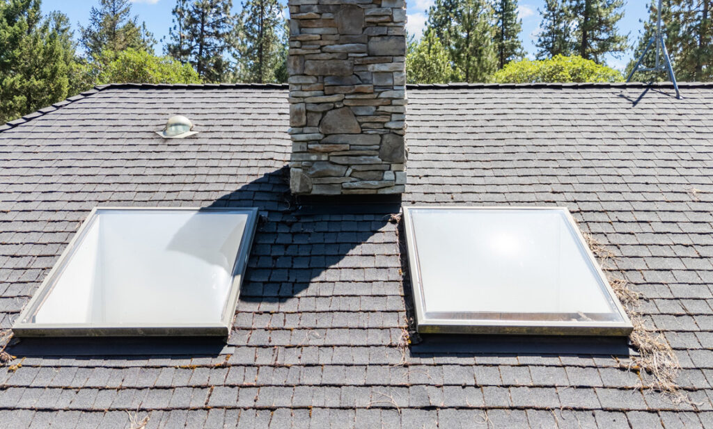 Contractor inspecting skylight head flashing on a residential roof in Camas, Washington