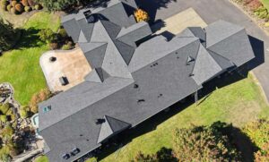 Roofer checking asphalt shingle condition and granule loss to estimate remaining roof life, HOMEMASTERS
