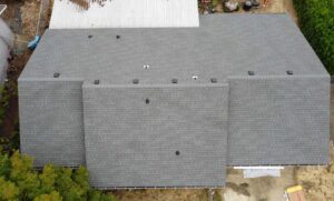 Overhead view of a new gray shingle roof with box vents and gutters, roof replacement cost guide for Klamath Falls