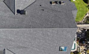 Overhead view of a new dark shingle roof with a flush glass skylight and roof vents, skylight replacement for Cottage Grove