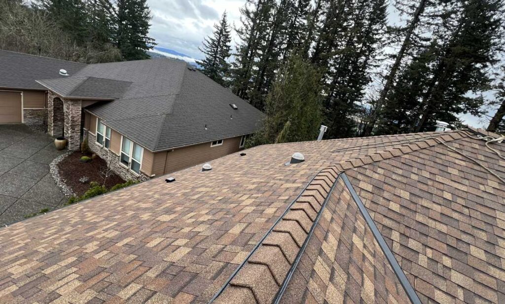 New architectural shingle roof with ridge cap and metal valley on a Washougal hillside home, HOMEMASTERS roof inspection